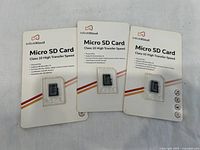 Three Infinitikloud Micro SD Cards in original packaging, two 64GB and one 32GB, displayed on white background.