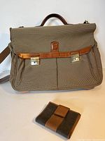 Tan fabric and leather briefcase alongside matching tan leather wallet, showing full frontal view with metal clasp closures and leather handle.