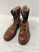 Front view of the brown leather boots showing laces, toe shape, and condition.