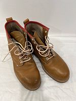 Pair of brown leather lace-up boots showing front and side view with laces tied