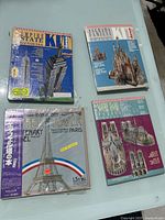 Four Editoriale Domus architectural paper model kits: Empire State Building, Sagrada Familia, Eiffel Tower, and Notre Dame in original boxes.