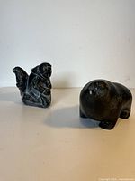Two soapstone Inuit sculptures shown side by side on white background, displaying overall size and shape