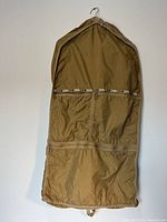 Full open view of vintage tan LeSportsac wardrobe travel bag, displaying multiple compartments and hanging hook at the top.