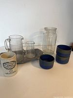 Photo showing 2 glass pitchers, etched small glass, ceramic mustard jar, three small blue and brown earthenware pots on Rogers Brothers Daffodil metal tray