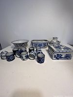 Full view of all porcelain items including Vienna Woods Fine China lidded jar, bowls, rectangular dish, and small napkin rings or cups arranged in front of plain background.