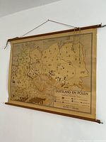 Full view of vintage map hanging on wall showing wooden rollers, string, and overall layout
