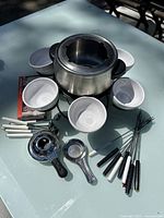 Photo of the full fondue set items including pot, stand, bowls, forks, spoons, and heating element.