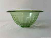 Side view of the ribbed green mixing bowl showing translucent Vaseline uranium glass material and shape.