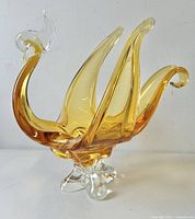 Side angle photo of amber and clear glass swan bowl showing the elongated wings and curled tail design.