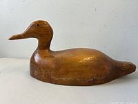 Front side view of the vintage carved pine wood duck decoy showing shape and wood grain details