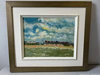 Front view of framed vintage oil painting showing seaside village coastline, signature Nichols visible.
