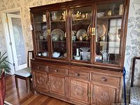 Front view of full cabinet showing four glass doors, drawers and base doors with carved motifs