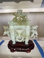 Front view of jade sculpture on wooden stand
