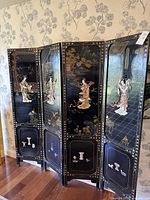 Side angle view of the four-panel folding screen showing artwork and design details.