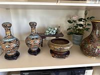 Overview of jade sculpture, two small vases, decorative bowl and large vase on shelf