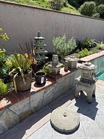 Group shot showing all five concrete garden ornaments placed on poolside ledge
