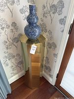 Full view of vase on stand in corner setting