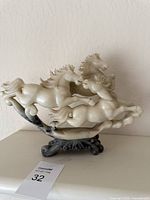 Front view of marble horse sculpture showing all three horses on base