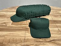 Sixteen hunter green baseball caps stacked together showing front and side views
