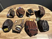 Photo showing all 8 gloves arranged on a wooden table, revealing various colors, brands and designs.