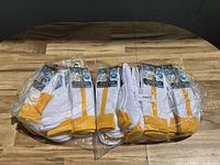 Two large packets containing multiple pairs of white socks with a yellow stripe and yellow toe and heel areas, packaged in clear plastic wrapping.
