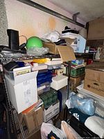 Photo showing two heavy duty metal shelves filled with packed boxes and household items in a storage space.