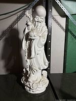 Front view of the white Chinese figurine showing details and condition.