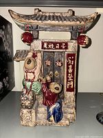 Front view of ceramic vase depicting children and traditional Chinese gate with lanterns.