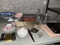 Overview photo showing all items on the table including porcelain plates, snuff bottles box, lighters, ceramic vase and terra cotta pot