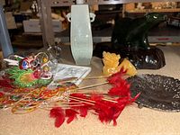 Overview of all items including bear sculpture on wood, yellow mythical lion figurine, celadon vase, paper lanterns with feathers, and metal dish.