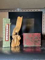 Wood carving bird approximately 23 cm tall, two decorative boxes: one green with Chinese script label and one red floral patterned
