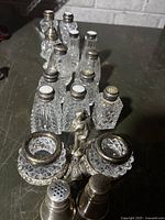 Group view of cut glass salt and pepper shakers with sterling silver tops, and other miscellaneous items including double salt cellar with cherub figure