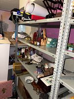 Full view of heavy duty metal shelving unit with four shelves containing various items, not included in sale.