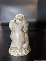 Front and side views of the Inuit soapstone figurine showing the full figure and held object