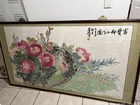 Full view of the large horizontal Chinese floral painting featuring pink peonies and green plants in a golden frame.