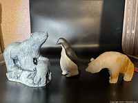 Photo showing the three animal figurines: polar bear with cub, penguin, and white/yellow stone bear.