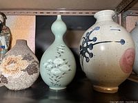 Overall view of three vases side by side on shelf