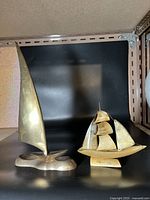 Both ship models shown on shelf with black backdrop, highlighting the difference in materials and designs.