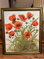 Full view of framed oil painting showing red poppies and green leaves with a cream background.
