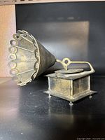 Music box angled showing horn speaker with decorative circular cutouts and base supported by feet