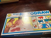 Box front showing the Rotodraw drawing game with children using it and farm animal tracing examples.
