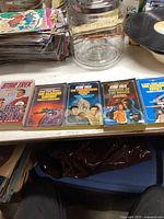 Five Star Trek books lined up on a table, showing colorful covers depicting starships and characters.