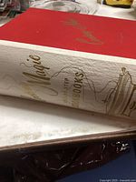 Photo showing spine of large hardcover cookbook titled 'Cooking Magic The Step Sister Cookbooks' with red and white cover.
