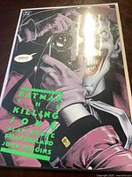 Front cover of Batman The Killing Joke comic book showing Joker holding a phone and text of title and creators.