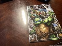 Photo of the Teenage Mutant Ninja Turtles Universe #1 comic book cover showing colorful illustrated characters including the turtles and a rat-like figure.