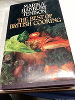 Front cover of the hardcover cookbook showing the title, author, and image of vegetables and seafood.