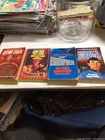 Four Star Trek paperback books laid out on a table in a row with visible front covers.