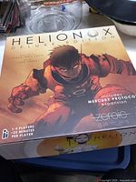 Front cover of Helionox Deluxe Edition board game showing astronaut artwork and game title