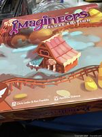 Box front showing a candy house from the game with author and publisher names