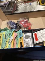 Opened Spider-Man Monopoly game box showing colorful paper money, cards, and plastic tokens still in plastic bags.